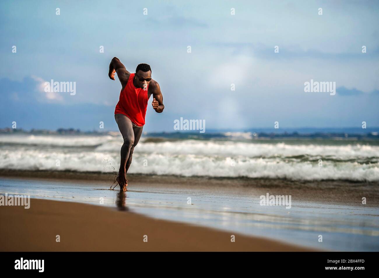 Jeune coupe attrayante athlétique et fort noir Africain américain homme courant à la plage entraînement dur et sprint sur l'eau de mer dans professionnel athl Banque D'Images