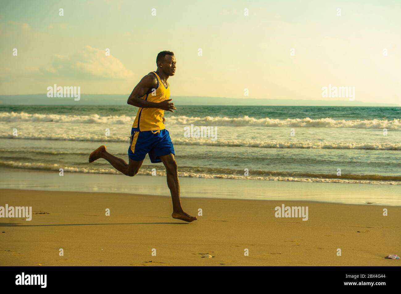 Jeune coupe attrayante athlétique et fort noir afro américain homme courant à la plage entraînement dur et sprinting sur l'eau de mer en athlète professionnel Banque D'Images