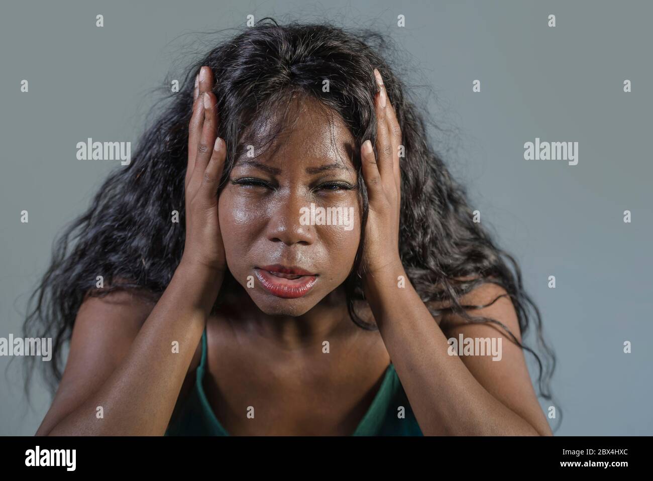 Jeune femme africaine noire américaine folle, désespérée et anxieuse, se sentant stressée et tourmentée dans une expression faciale intense et dramatique isolée sur le goujon Banque D'Images