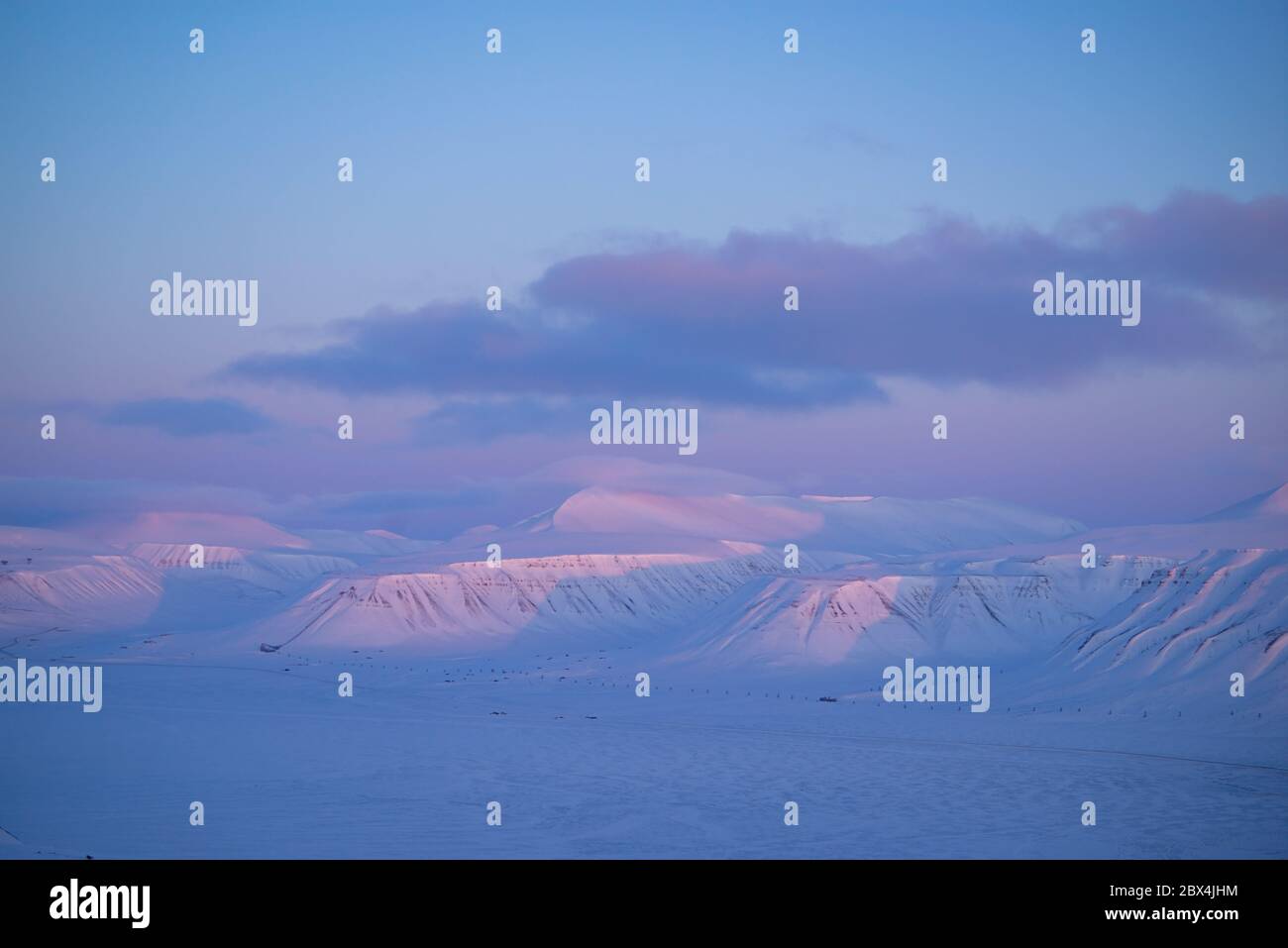 Paysage arctique avec montagnes enneigées et lumière rose sur le Spitzbergen Banque D'Images