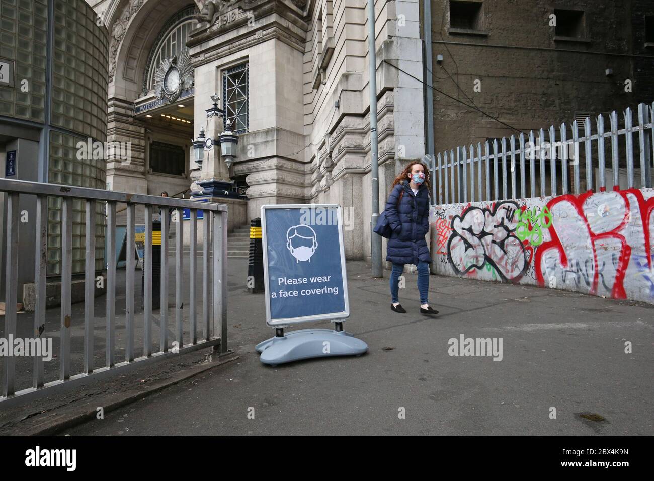Une affiche demandant aux gens d'utiliser des revêtements de visage à l'extérieur de la gare de Waterloo à Londres, suite à l'annonce que le port d'un revêtement de visage sera obligatoire pour les passagers des transports en commun en Angleterre à partir de juin 15. Banque D'Images