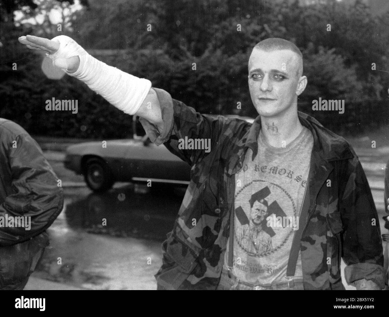 Berlin-Spandau / Nazis / groupes de droite 20.8.1987 devant la prison des criminels de guerre de Spandau, Rudolf Hess vient de mourir. Les groupes de droite se rassemblent en deuil. Une tête de peau avec un T-shirt portant un portrait d'Hitler, une croix gammée et l'inscription suivante: -pas de remords-, -pas de regrets- // nazi / fascisme / *** Légende locale *** la prison pour les criminels de guerre à Berlin-Spandau. Le dernier prisonnier, Rudolf Hess, est mort juste après 46 ans dans la prison montrée en arrière-plan. Les gens de droite se rassemblent pour pleurer. Cette tête de peau est dotée d'un t-shirt avec une croix gammée, une photo d'hitler et Banque D'Images