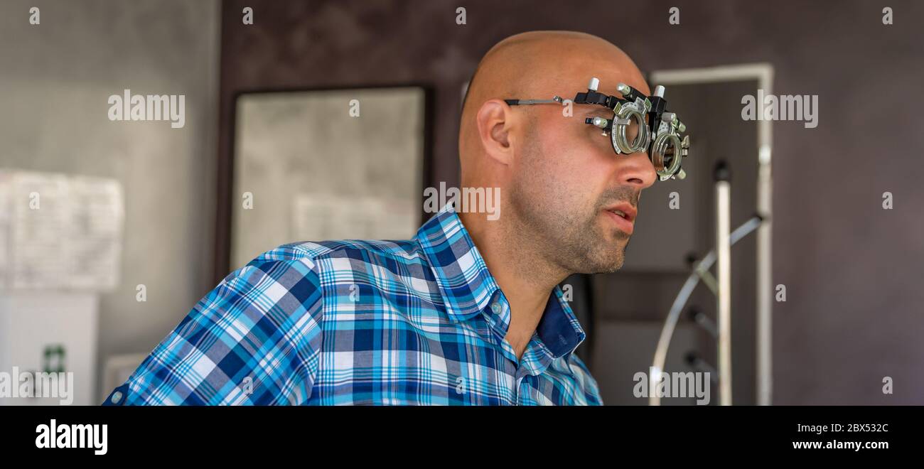 examen oculaire par optométriste à la clinique, jeune homme comme patient Banque D'Images
