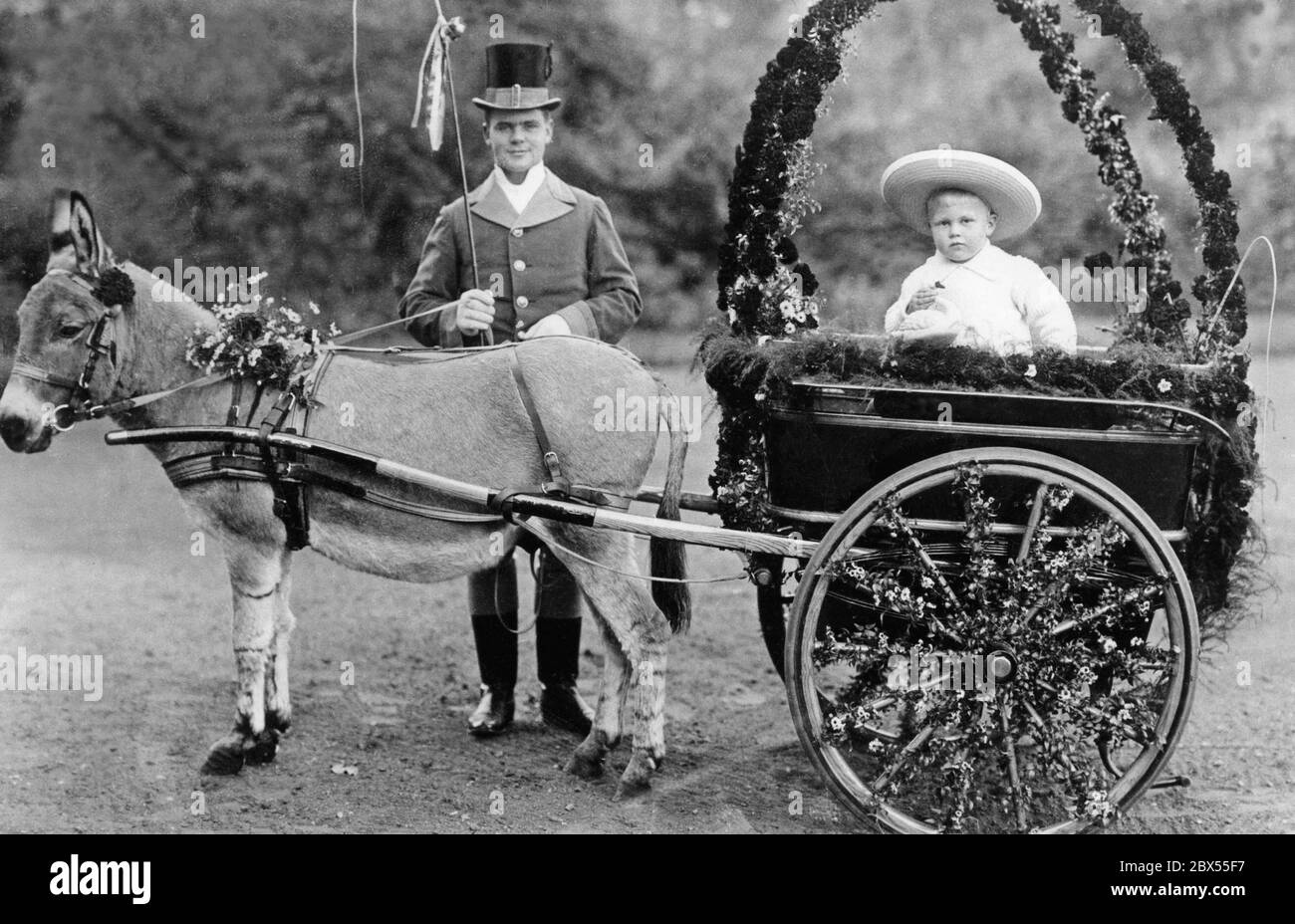 Le prince héréditaire Friedrich Franz von Mecklembourg-Schwerin est décoré de fleurs dans un chariot à âne. À côté de lui se trouve le serviteur du prince et le garde du corps. Banque D'Images
