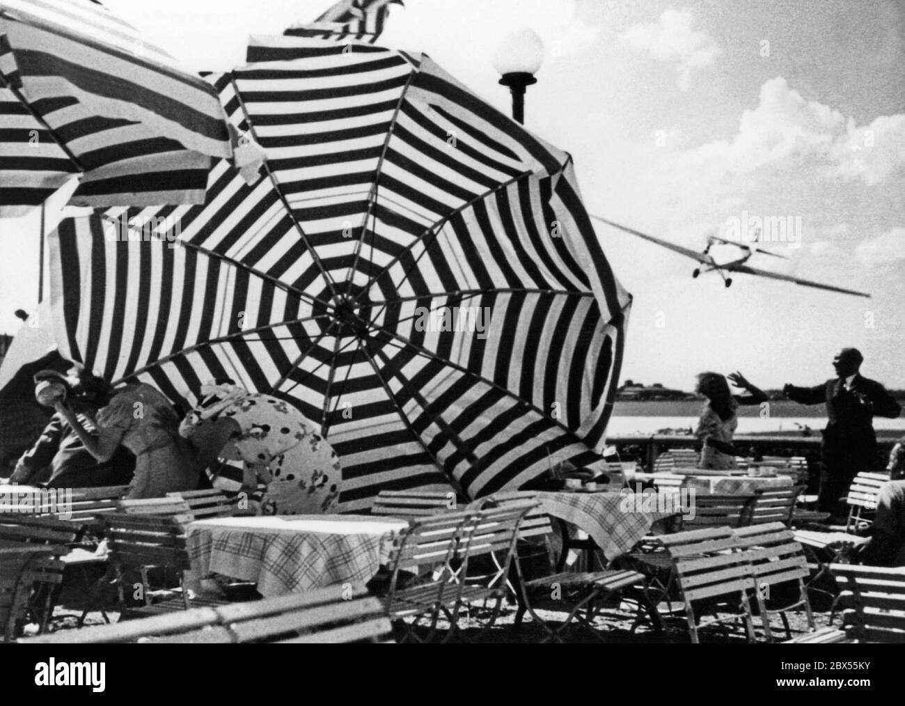 L'ancien pilote de chasse Ernst Udet, après Manfred von Richthofen, l'as de vol le plus réussi de la première Guerre mondiale, vole des cascades au-dessus de l'aéroport de Berlin Tempelhof. La photo montre des scènes d'un tournage pour le film 'Miracle of Flight' dans lequel Udet renverrait des parasols avec ses ailes. Banque D'Images