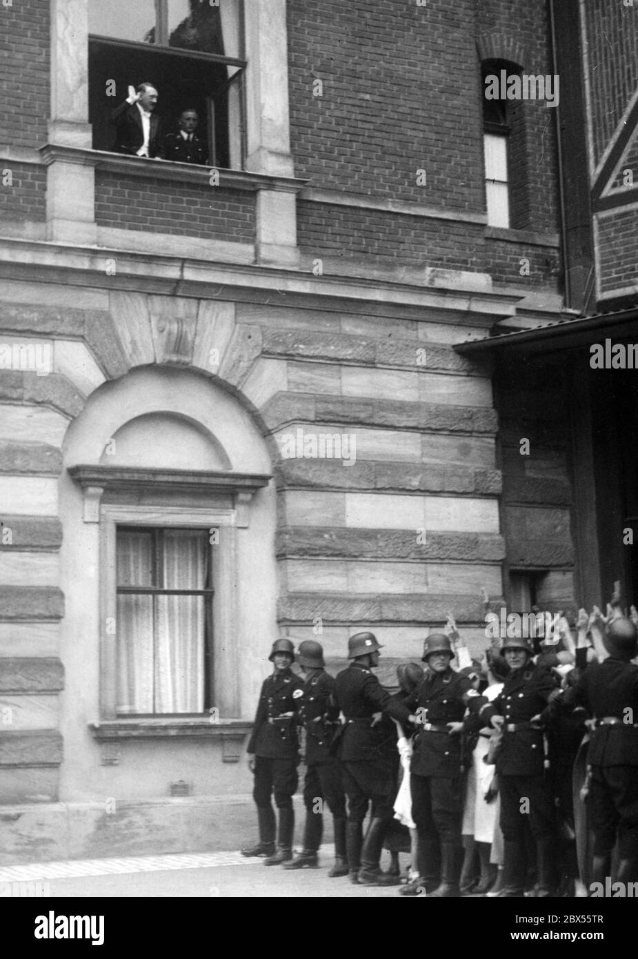 Adolf Hitler apparaît à la fenêtre de la Festspielhaus. Devant la fenêtre, les soldats gardent les invités de la fête dans la baie. Banque D'Images