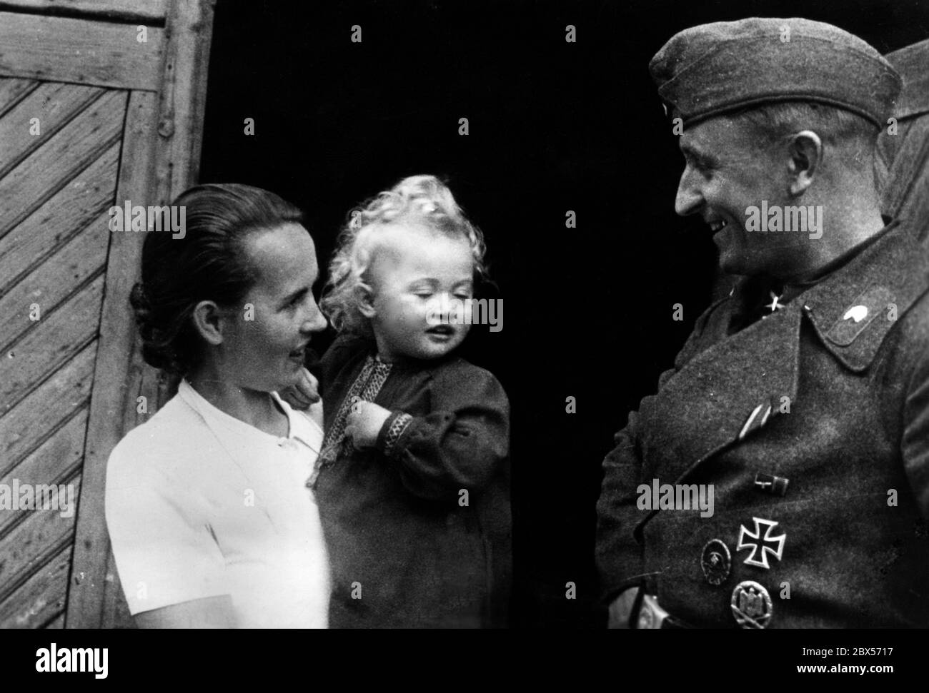 Le sergent d'état-major Heinrich Banze, qui a reçu la Croix de Chevalier de la Croix de fer lors d'une mission de la 113e division d'infanterie, est ici en congé à Hofgeismar, à Kurhessen, avec sa femme et son enfant. Sur sa veste uniforme gris champ, il porte l'insigne de Wound (Verwundetenabzeichen), l'insigne d'infanterie (Infanterie-Sturmabzeichen) et la Croix de fer de 1ère classe. Banque D'Images