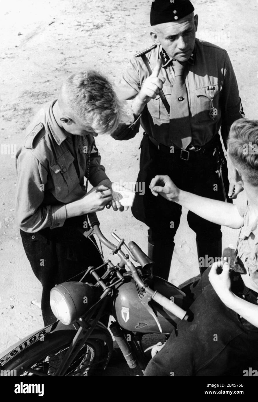 Lors des leçons de conduite à la « Potsdamer Platz » dans le Nordoer Heide, un contrevenant de la circulation automobile HJ est rébuté par un membre de NSKK. Le conducteur de la moto doit payer une amende de cent. Probablement une photo mise en scène. La moto est de type DKW RT 98 cc. Banque D'Images