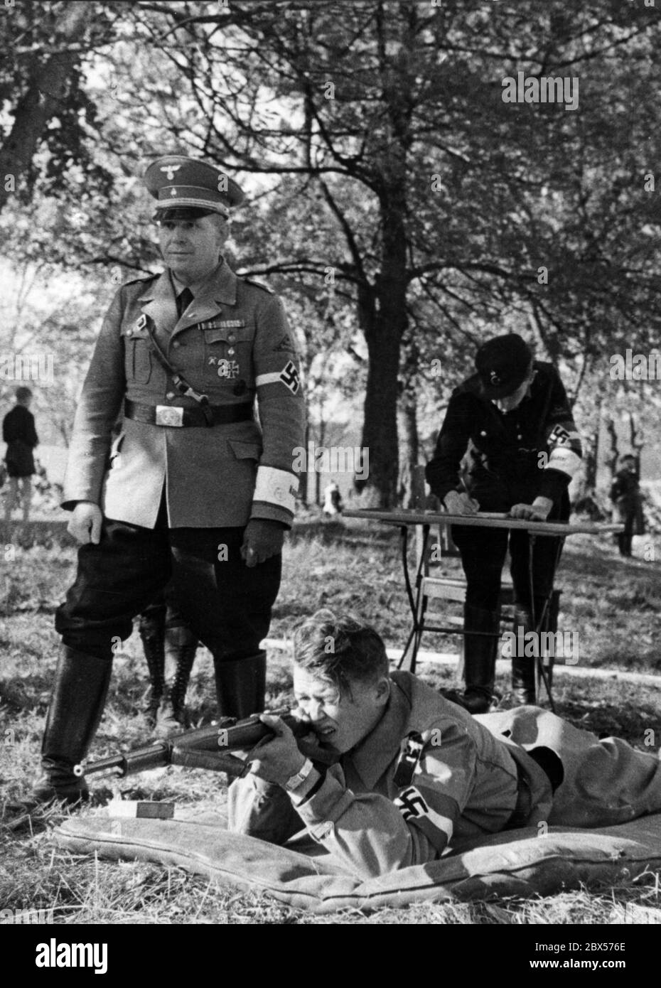 Au cours du 7ème Reichstreffen du Motor HJ à Bad Gandersheim a lieu une compétition de tir de petit calibre. L'image montre un participant qui a tiré en étant couché. Un homme NSKK le regarde sur la photo. En arrière-plan, un autre membre de NSKK écrit. Banque D'Images