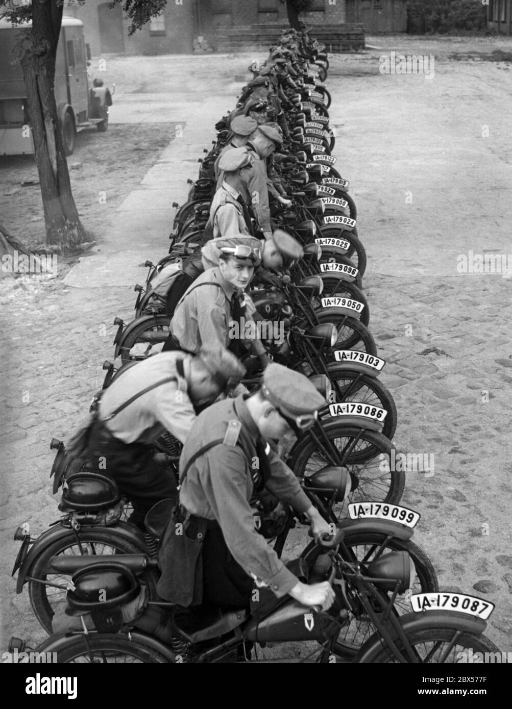 Les motos de type DKW 98cc sont garées de suite et sont démarrées par des membres du Motor-HJ. Les jeunes vont faire du vélo de Lichterfelde à Goslar. Banque D'Images