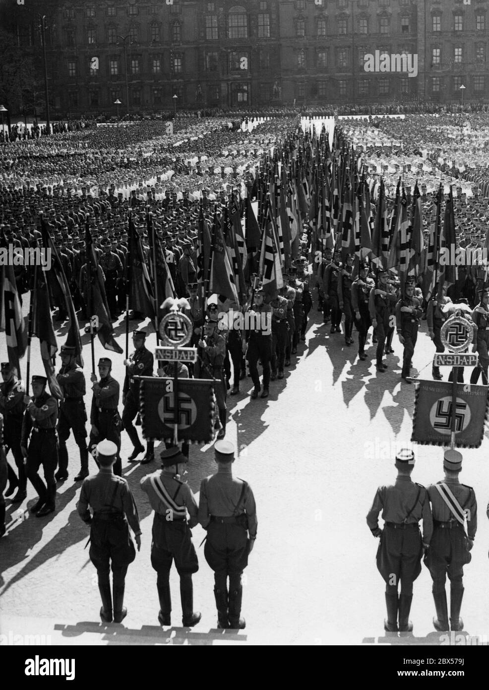 A l'occasion de l'anniversaire d'Adolf Hitler, les membres de l'Australie méridionale défilent avec des drapeaux de tempête au Palais de Berlin. Au premier plan, il existe une norme sa. Banque D'Images