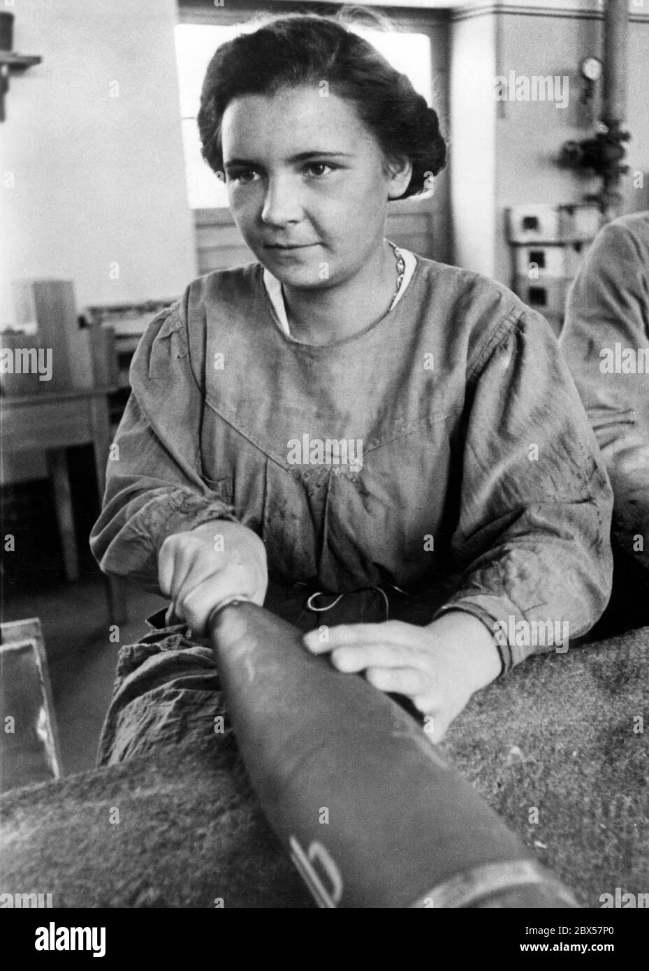 Ce jeune travailleur nettoie les grenades finies. Banque D'Images