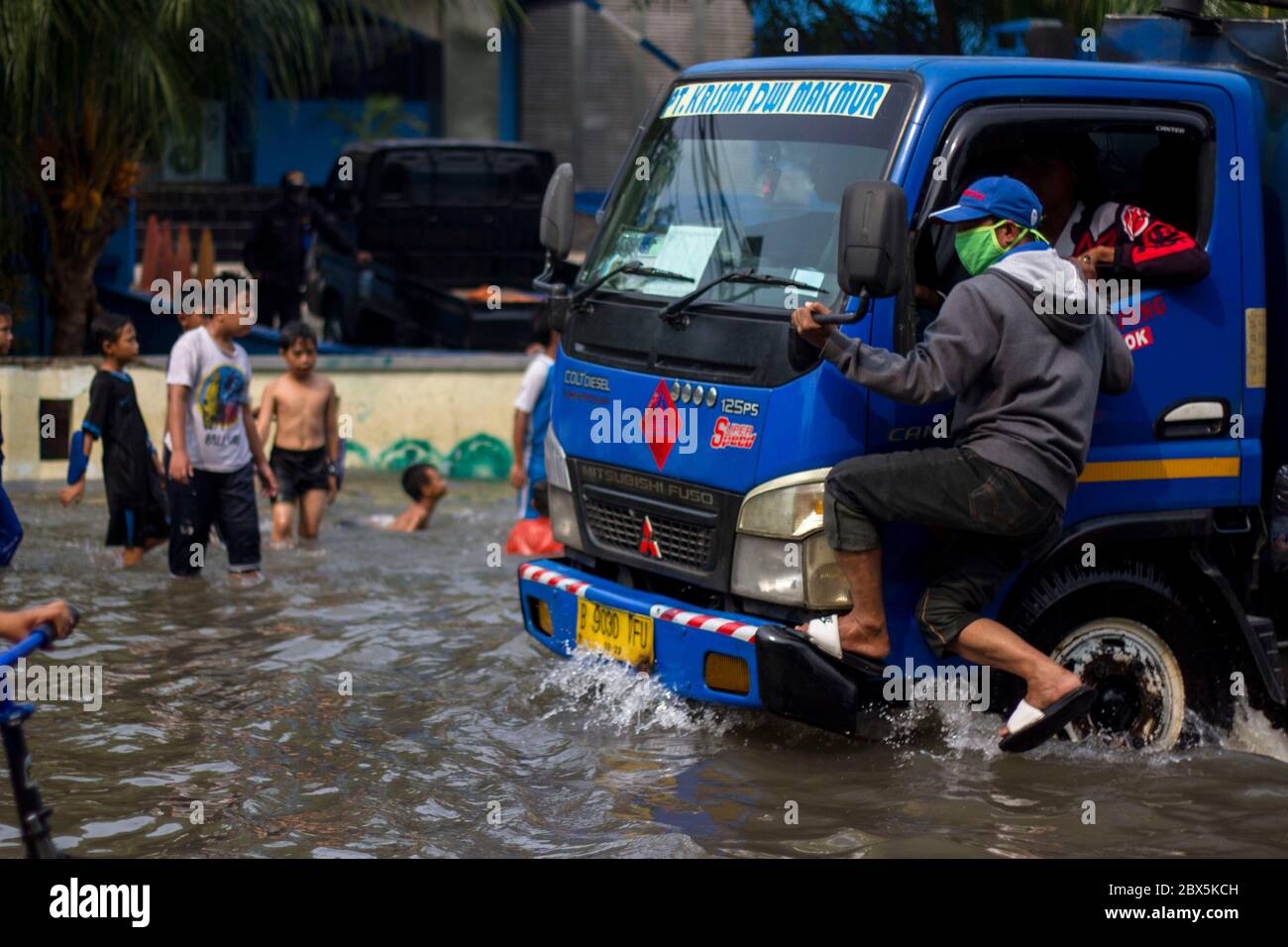 Jakarta, DKI Jakarta, Indonésie. 5 juin 2020. Un homme porte un masque incliné sur un camion pour éviter une flaque d'eau de mer qui absorbe la zone côtière de Jakarta. En raison de l'eau de mer répandue le long du littoral nord a provoqué l'inondation de certaines zones en Indonésie. Crédit : Muhammad Zaenuddin/ZUMA Wire/Alay Live News Banque D'Images