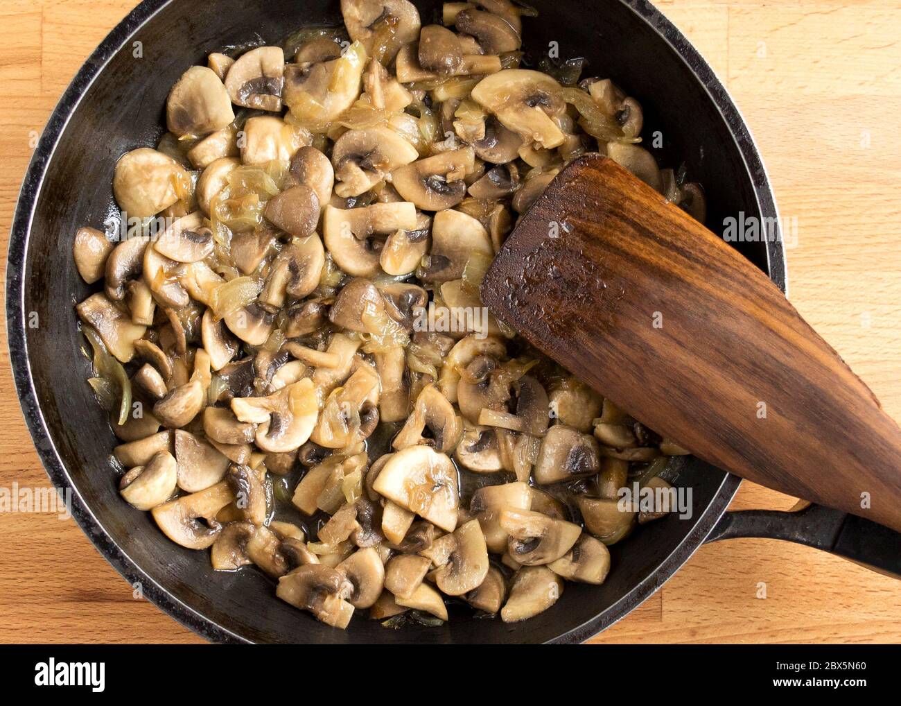 Préparer les champignons et les oignons dans une casserole noire. Faire sauter les champignons et les légumes dans l'huile. Vue de dessus sans personnes. Banque D'Images