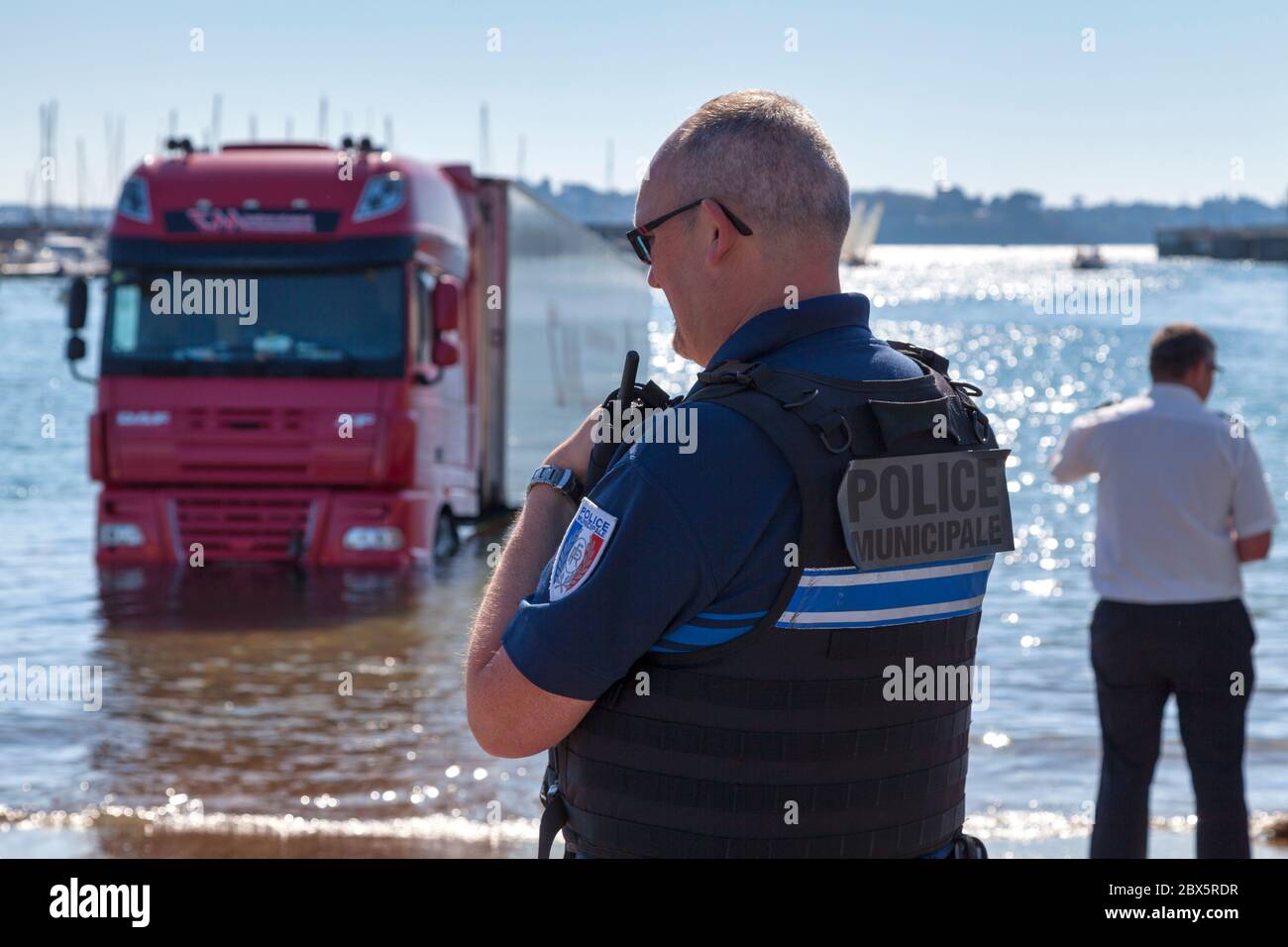 Saint-Malo, France - juin 02 2020 : policier municipal en intervention au port à cause d'un camion surpris par la marée montante. Banque D'Images