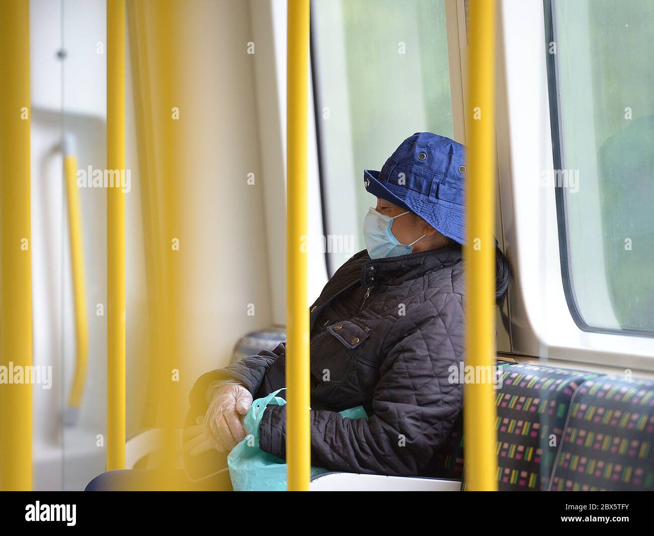 Un passager porte un masque facial sur un train souterrain District Line, suite à l'annonce que le port d'un masque facial sera obligatoire pour les passagers des transports en commun en Angleterre à partir de juin 15. Banque D'Images