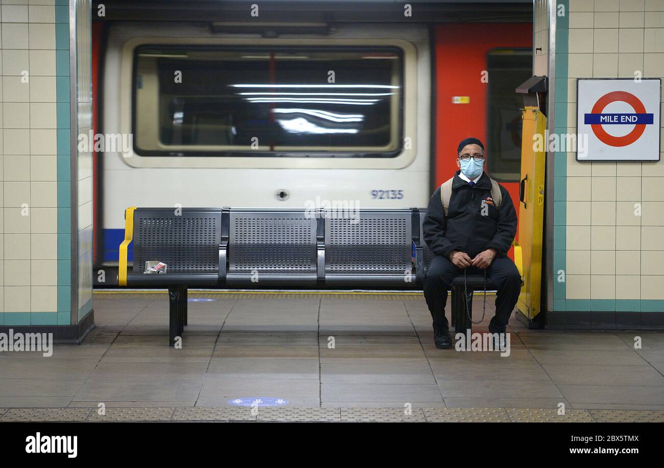 Un passager porte un masque facial pendant qu'il attend un train à la station de métro Mile End, suite à l'annonce que le port d'un masque facial sera obligatoire pour les passagers des transports en commun en Angleterre à partir de juin 15. Banque D'Images