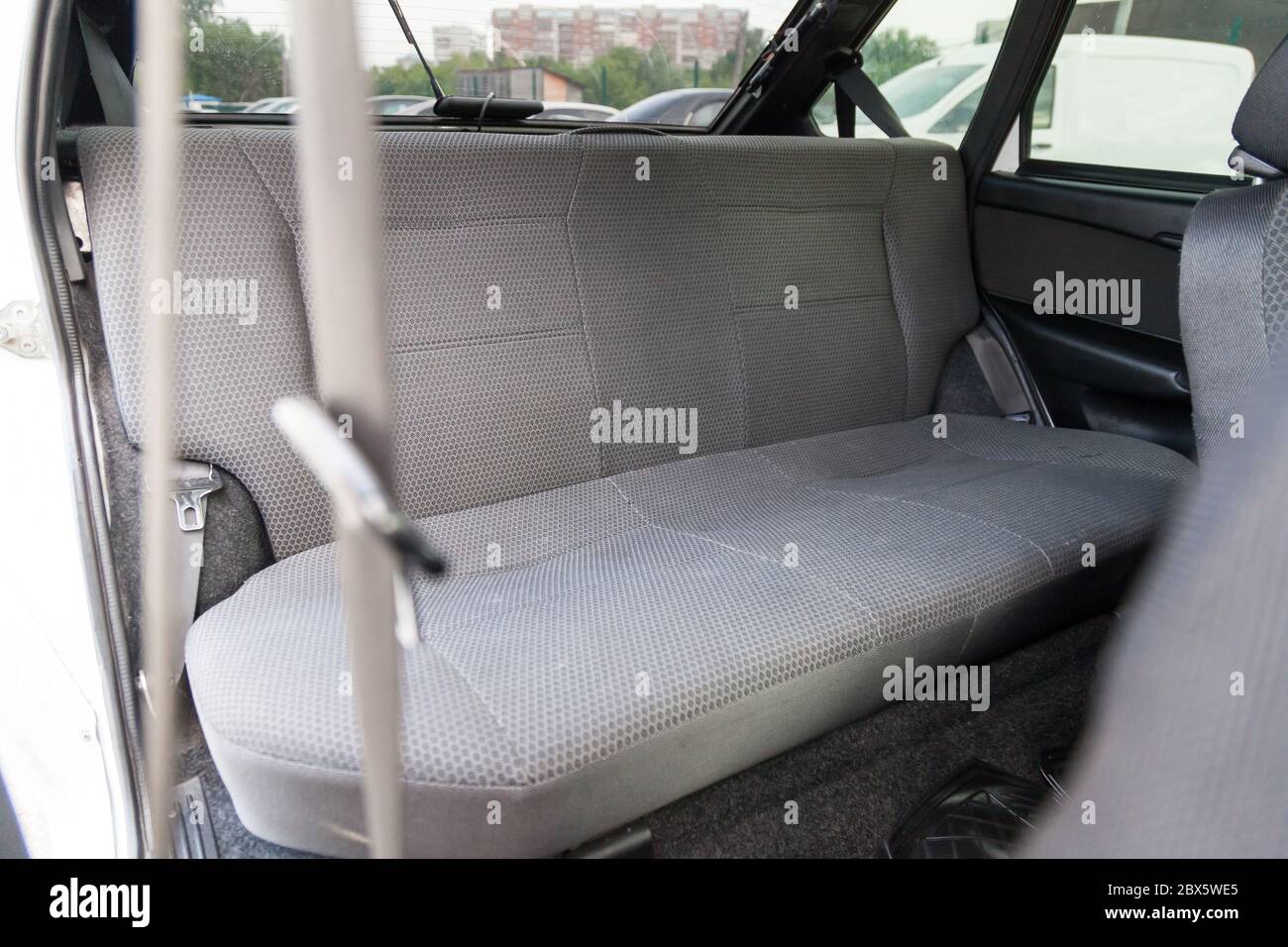La rangée arrière de sièges de passager tapissés en gris dans un vieux taxi russe après un lavage de voiture et de nettoyage à sec en service de voiture. Banque D'Images