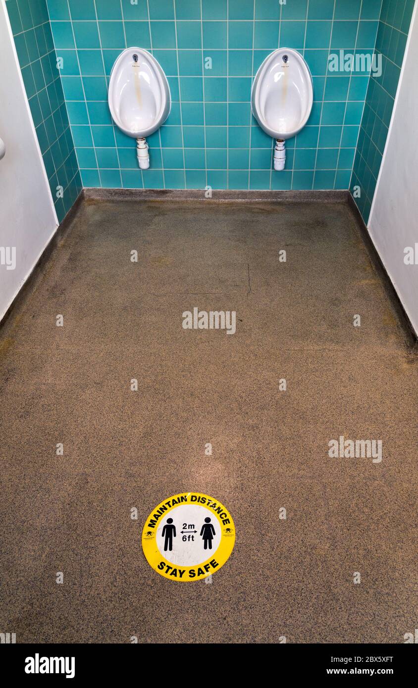 Toilettes de Gents avec panneau social-distancing Covid-19, Stainforth, parc national de Yorkshire Dales, Royaume-Uni. De manière amusante, le signe implique presque un unisex toilettes. Banque D'Images