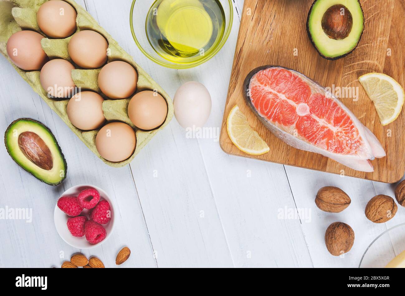 Keto alimentation, bas carb nourriture saine. Avocat, poisson, huile, noix sur fond blanc Banque D'Images