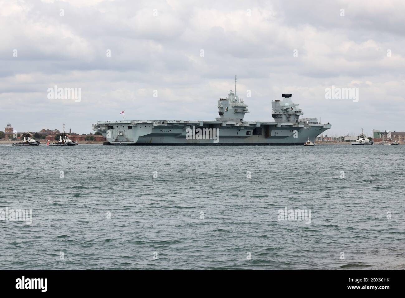 Une petite flottille de remorqueurs guide le porte-avions de la Marine royale HMS QUEEN ELIZABETH vers l'entrée du port ce matin Banque D'Images