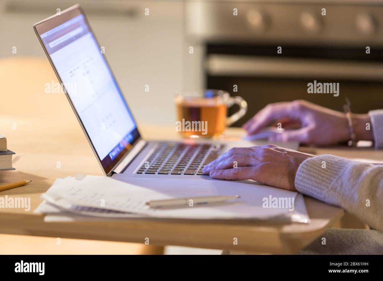 Gros plan de l'homme travaillant à la maison en utilisant un ordinateur portable, , en utilisant la souris d'ordinateur, tasse de thé floue sur l'arrière-plan. Indépendant, travail à distance, indépendant Banque D'Images