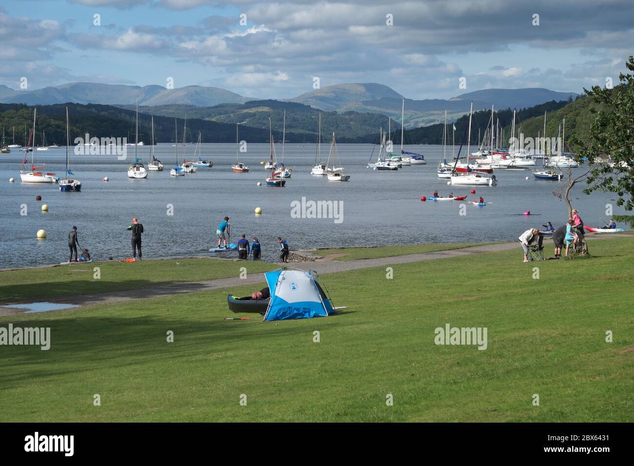 Les visiteurs, y compris les amateurs de sports nautiques, profitent d'une journée ensoleillée d'été au parc Fell foot sur Windermere, dans le parc national du Lake District Banque D'Images