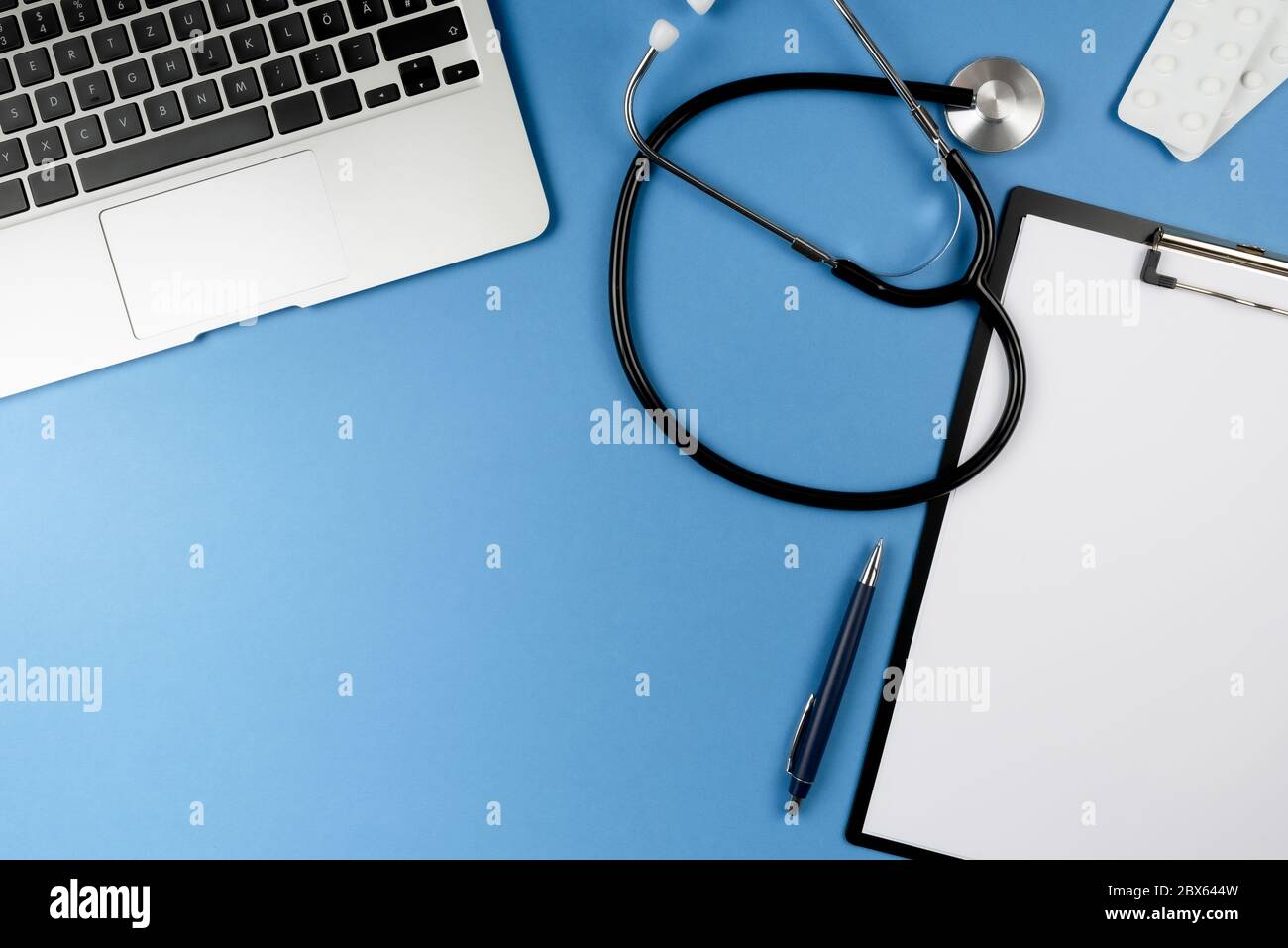 vue de dessus du bureau du médecin ou du médecin avec stéthoscope, ordinateur portable et presse-papiers avec feuilles de papier Banque D'Images