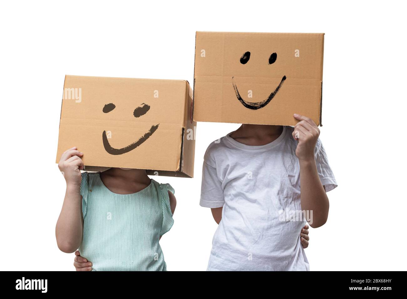 Deux petites filles portant une boîte en carton sur sa tête avec un visage smiley, isolée sur fond blanc. Banque D'Images