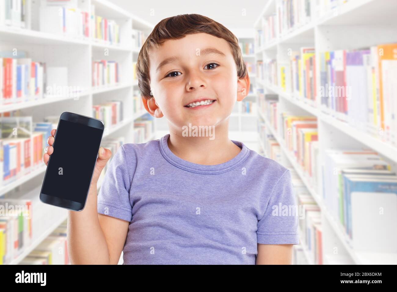 Petit garçon enfant tenant smartphone smartphone smartphone smartphone bibliothèque téléphone portable marketing publicité apprendre Banque D'Images