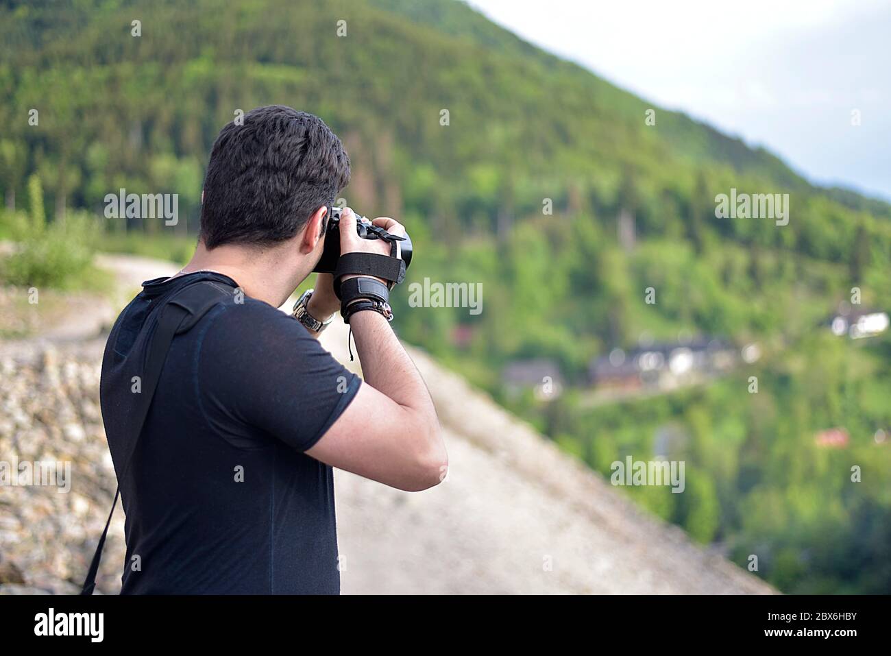 Homme photographiant avec un appareil photo professionnel beau paysage sur le sommet de la montagne Banque D'Images