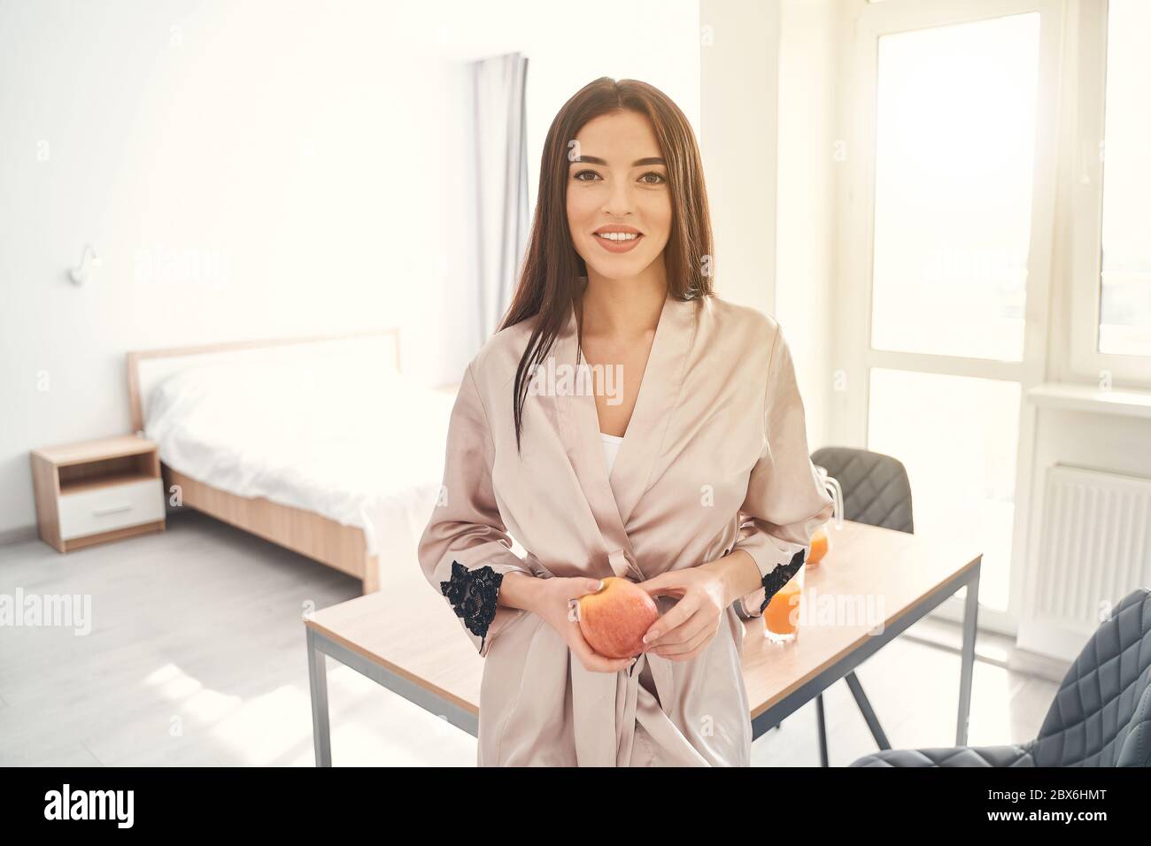 Jolie jeune femme posant à la maison avec une pomme dans les mains Banque D'Images
