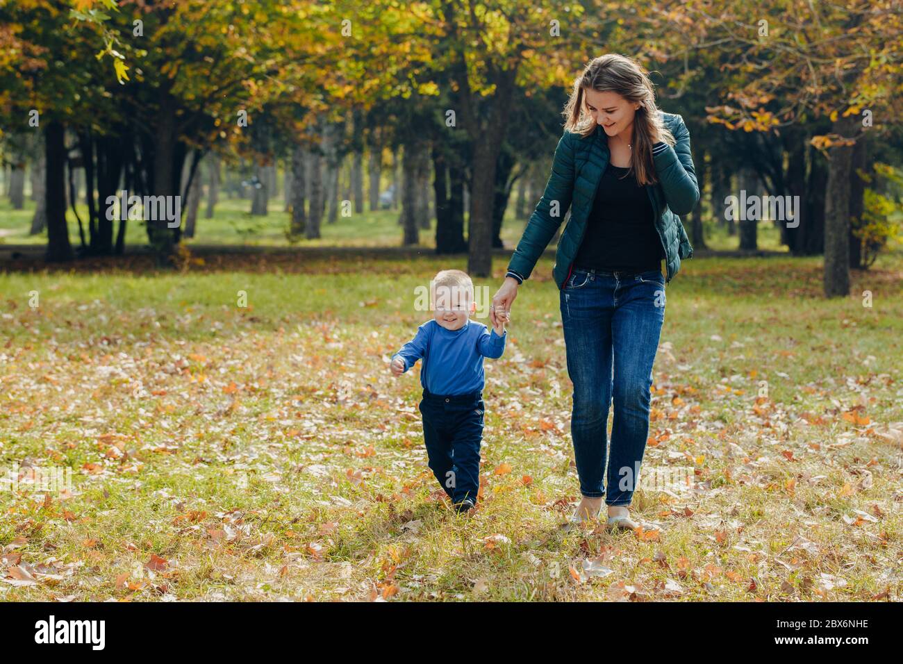 portrait d'une belle jeune mère avec son fils marche dans le parc d'automne. marche et jouer à l'extérieur Banque D'Images