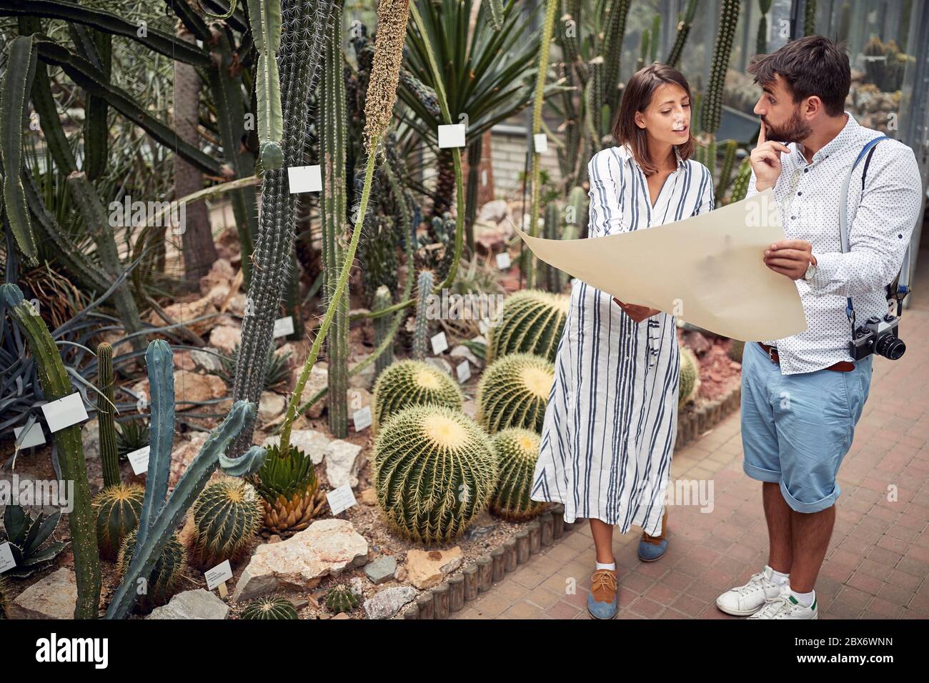 jeune biologiste caucasien expliquant la carte à un touriste mâle dans le jardin botanique Banque D'Images