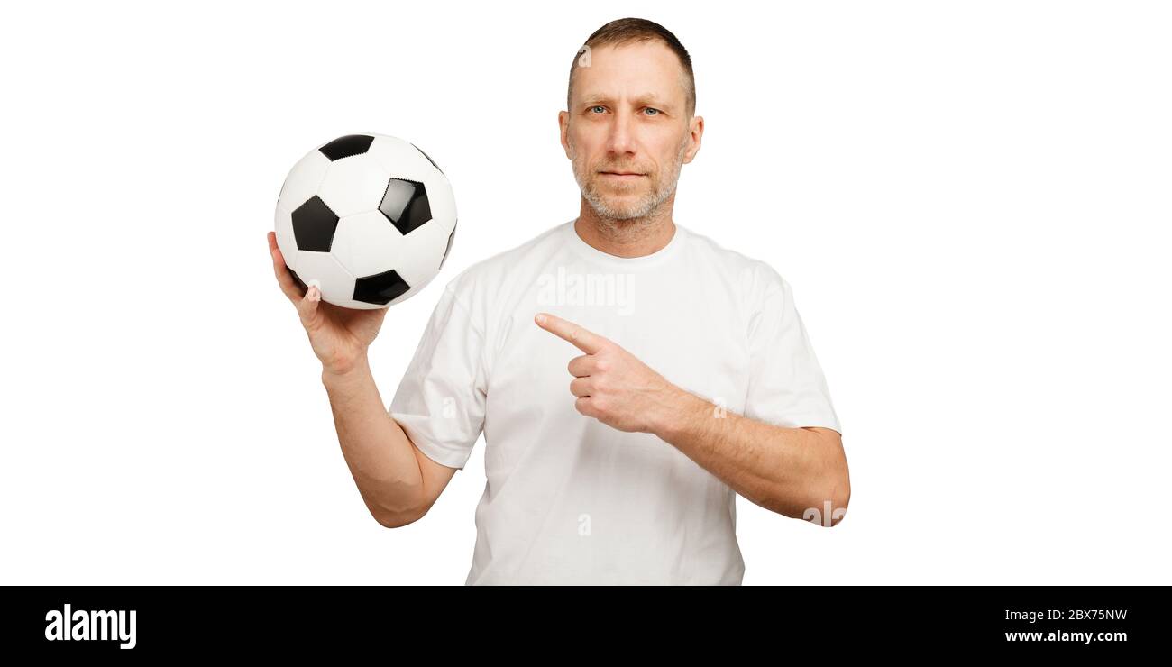 Un homme tient une balle de football et pointe un doigt dessus. Banque D'Images