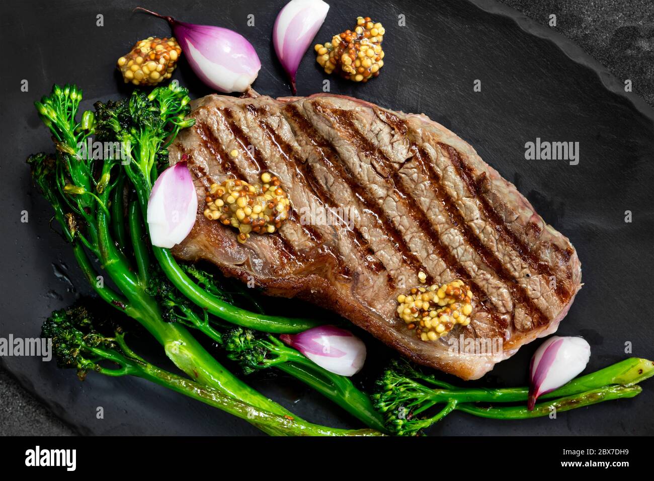Steak de Porterhouse, grillé au brocolis, échalotes marinées et moutarde. Vue de dessus sur ardoise. Banque D'Images