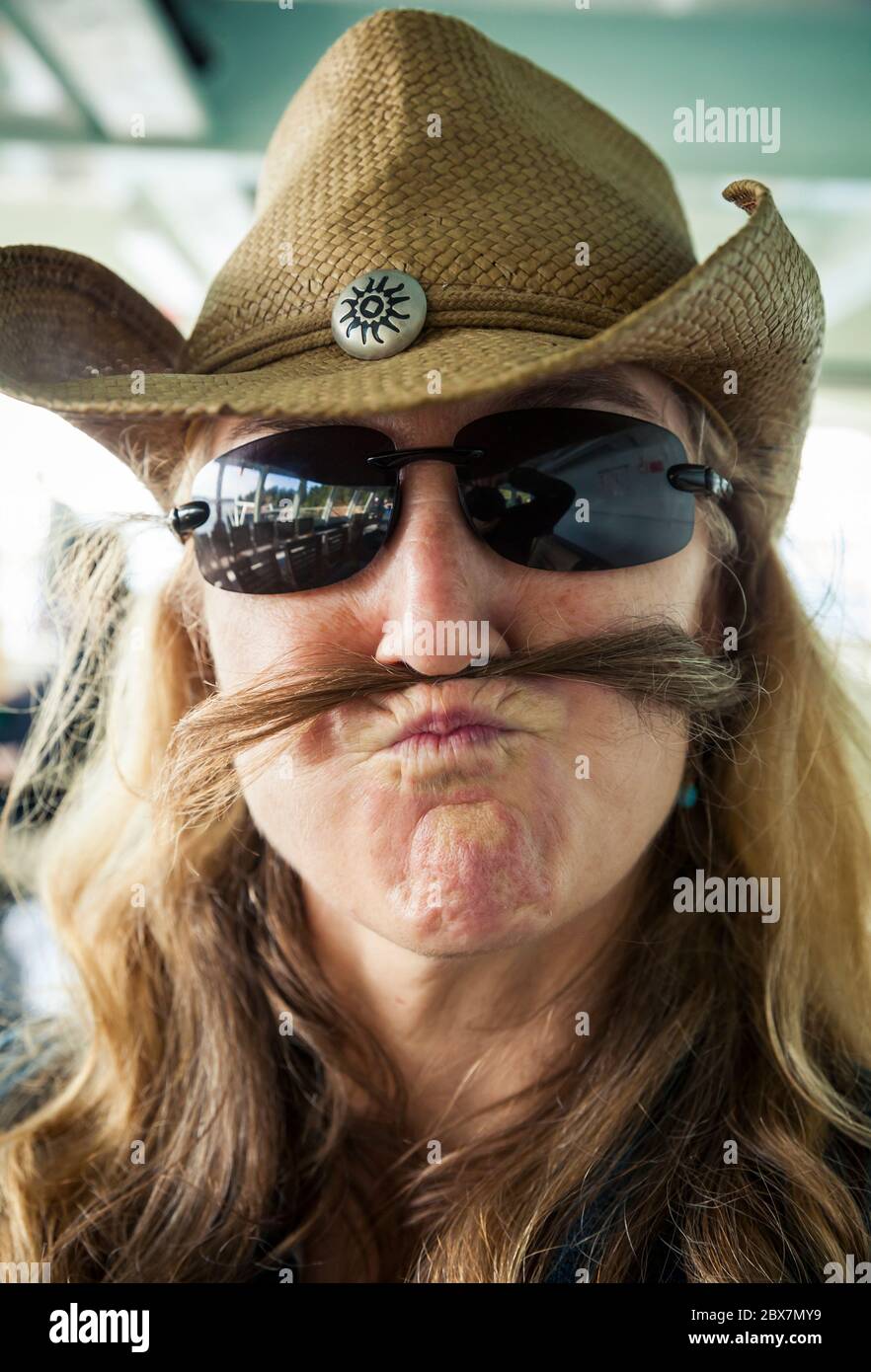 Une femme d'âge moyen qui se fait du bien et qui fait une moustache. Banque D'Images