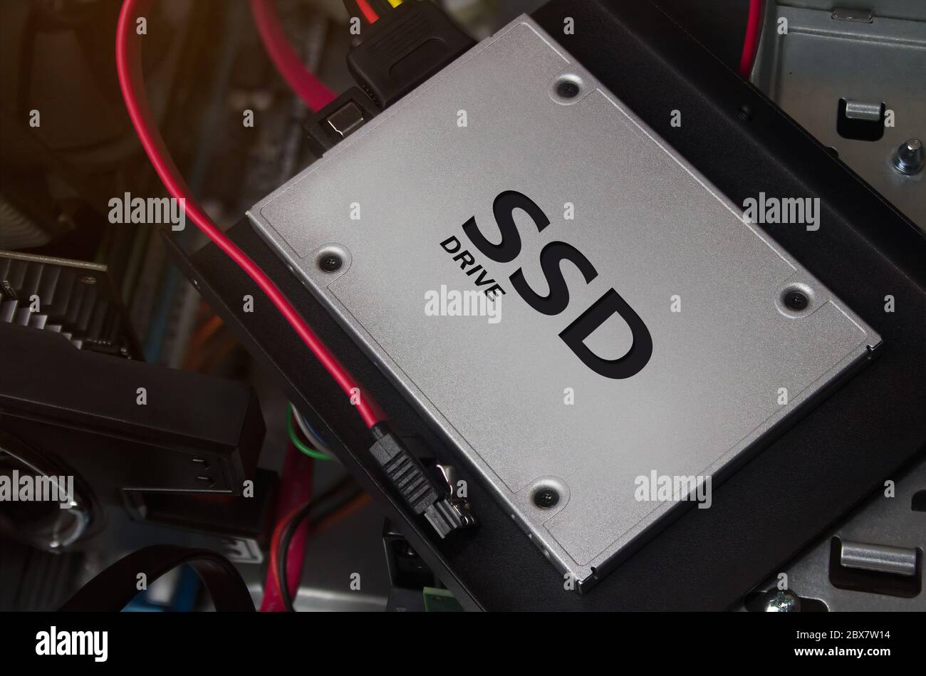 Lecteur SSD posé sur le boîtier de l'ordinateur avec câbles et supports. Banque D'Images