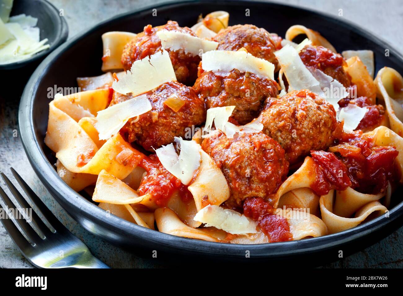 Boulettes de viande aux pâtes pampelles et au parmesan rasé. Banque D'Images