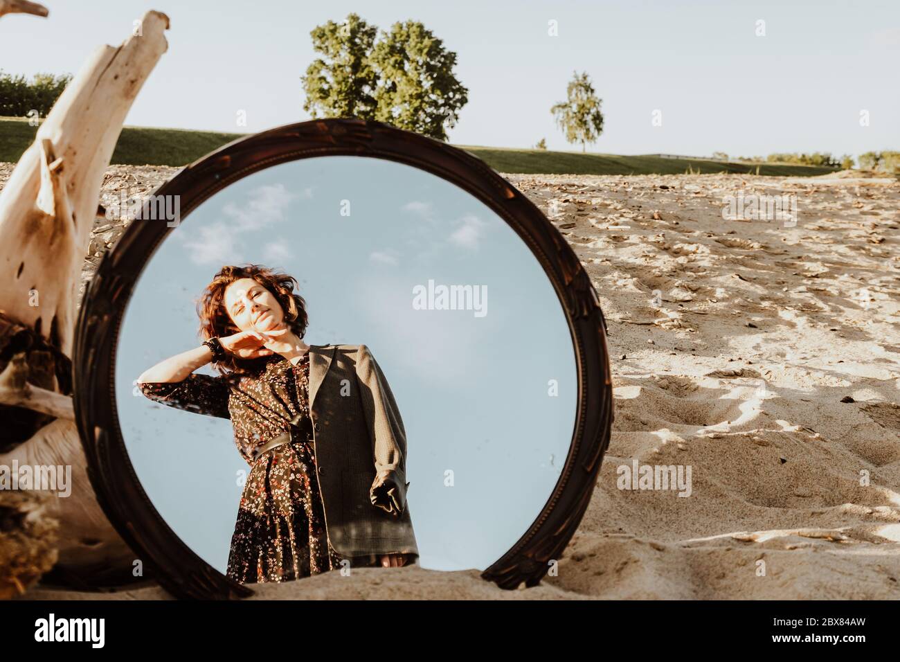 Femme frayeuse sur une plage ensoleillée en robe tenant sa veste avec ses  mains et marchant dans le reflet du miroir. Vie heureuse Photo Stock - Alamy
