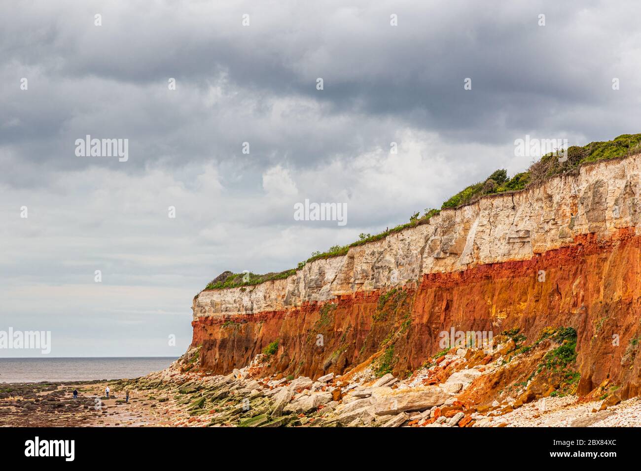 Roches sédimentaires orange, rouge et blanche le long de la plage à Hunstanton, Norfolk, East Anglia, Royaume-Uni. Banque D'Images