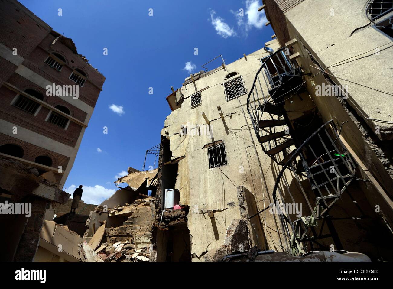 Les yéménites tamiser les décombres d'un bâtiment très endommagé à la suite de la coalition dirigée par les Saoudiens ont signalé des attaques aériennes dans la capitale du Yémen, Sanaa, le 16 mai 2019. Banque D'Images