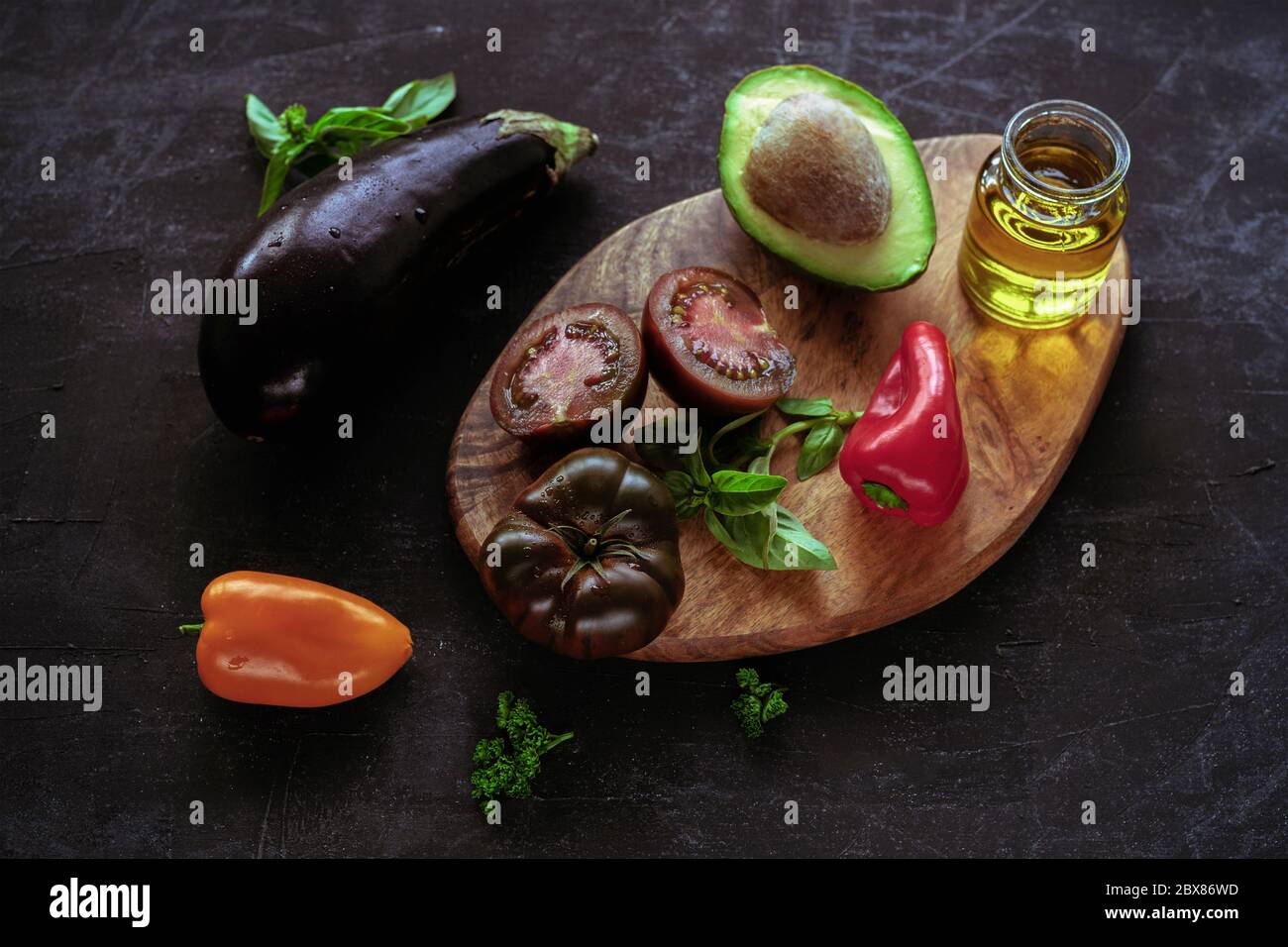 Légumes crus et huile d'olive sur planche à découper en bois, vue de dessus. Concept d'alimentation saine Banque D'Images