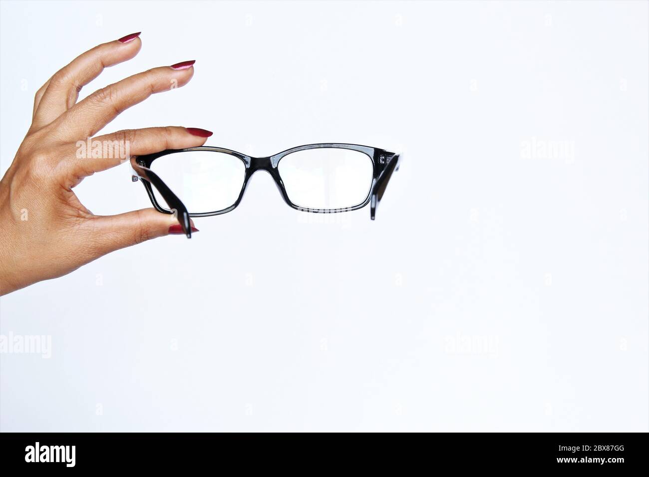 Femme montre main lunettes de signe. Photo isoler sur la vue avant blanche de l'espace de copie Banque D'Images