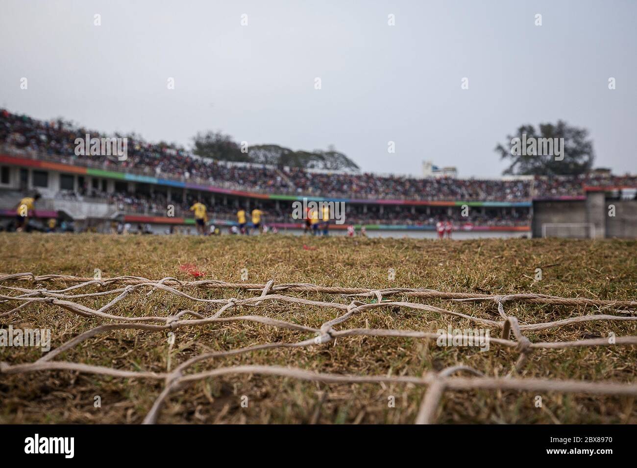 La culture de football de Kolhapur est tout à fait différente. C'est une tradition centenaire de football entre les clubs locaux. Kolhapur a le deuxième plus ancien club de football commercial { Jamdar Club} enregistré en Inde. Aujourd'hui, le kolhapur a six mois de saison de football joué parmi plus de 30 clubs avec des joueurs de football africal, nigérian avec des joueurs locaux. Aujourd'hui, le kolhapur observe fréquemment des affrontements entre les équipes. Cette image indicative souliers le filet de la poste de but et le jeu de football enveloppé. Banque D'Images