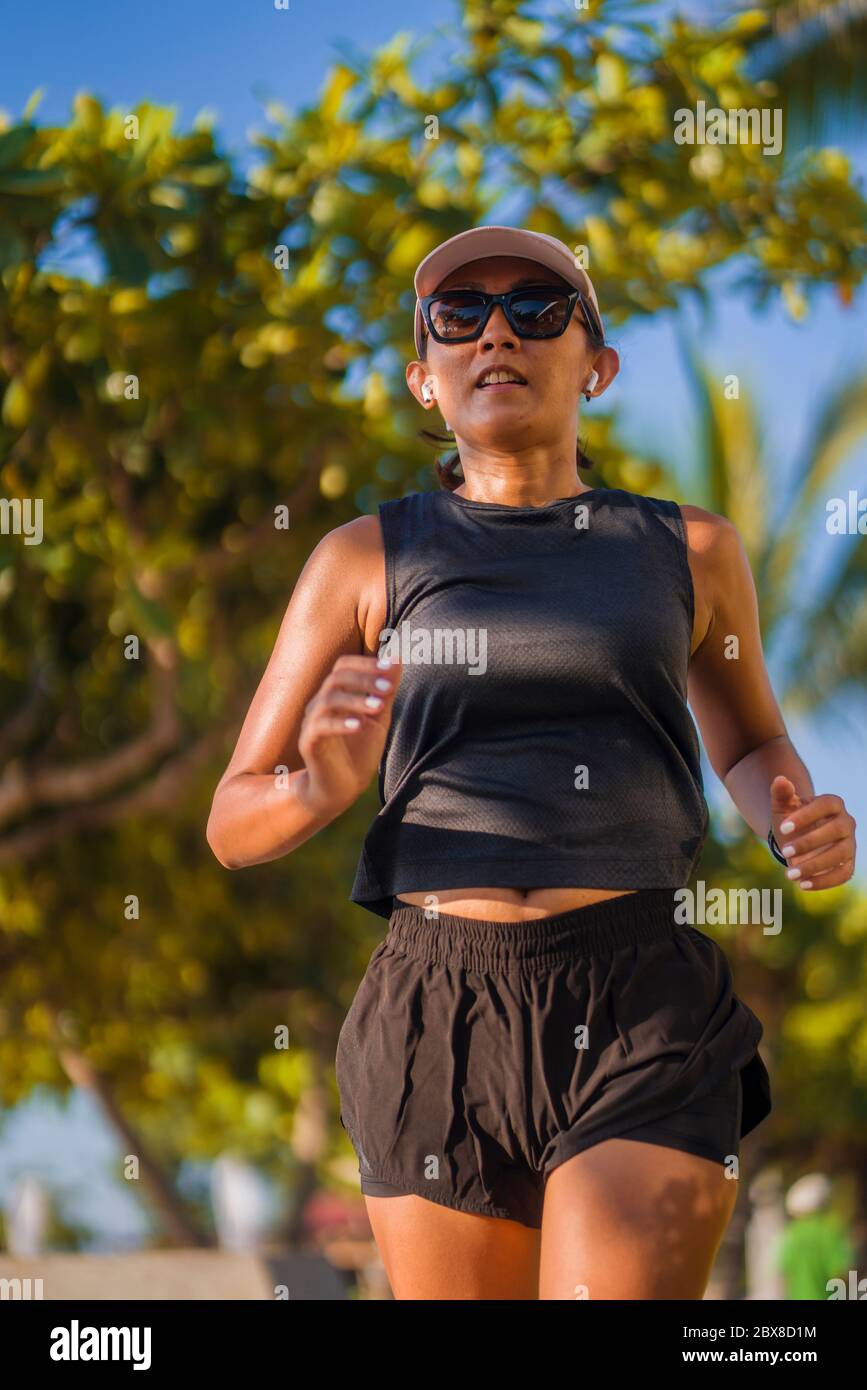 extérieur forme physique style de vie portrait de jeune femme attrayante et athlétique jogging heureux sur le parc de ville faire des exercices d'intervalles dans l'entraînement d'athlète a ru Banque D'Images