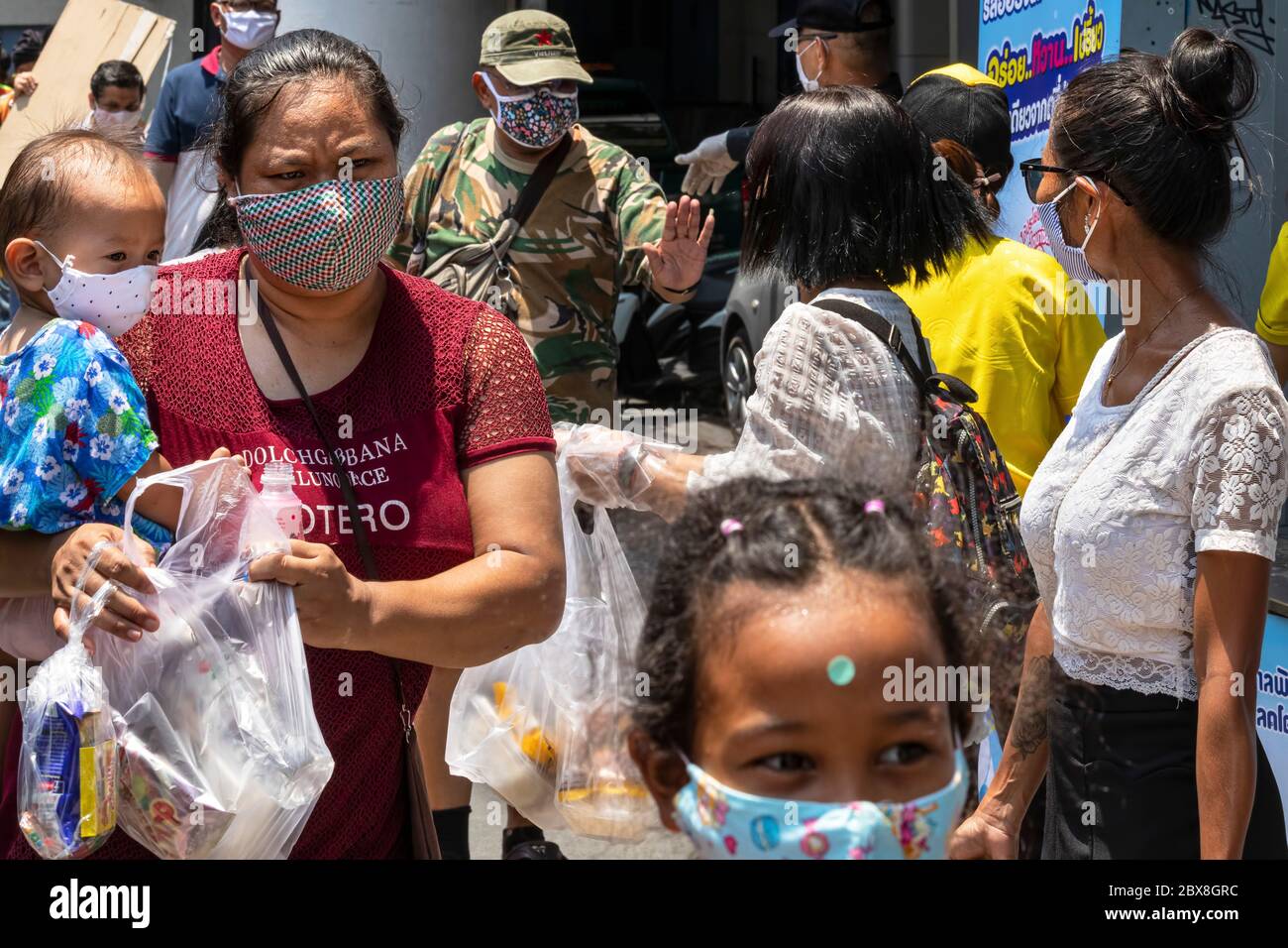 Des volontaires donnent des sacs en plastique avec de la nourriture aux pauvres pendant la pandémie de Covid, Bangkok, Thaïlande Banque D'Images