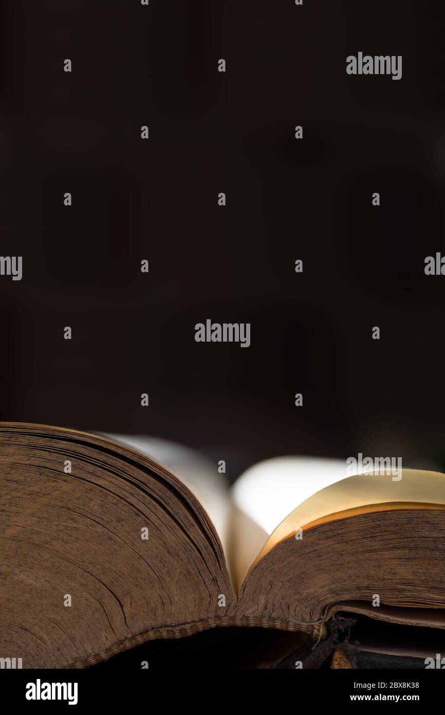 Ouvrez un vieux livre ou une bible avec un motif dans le bord des pages avec l'atmosphère d'or et cousu reliure. Image verticale, espace de copie Banque D'Images
