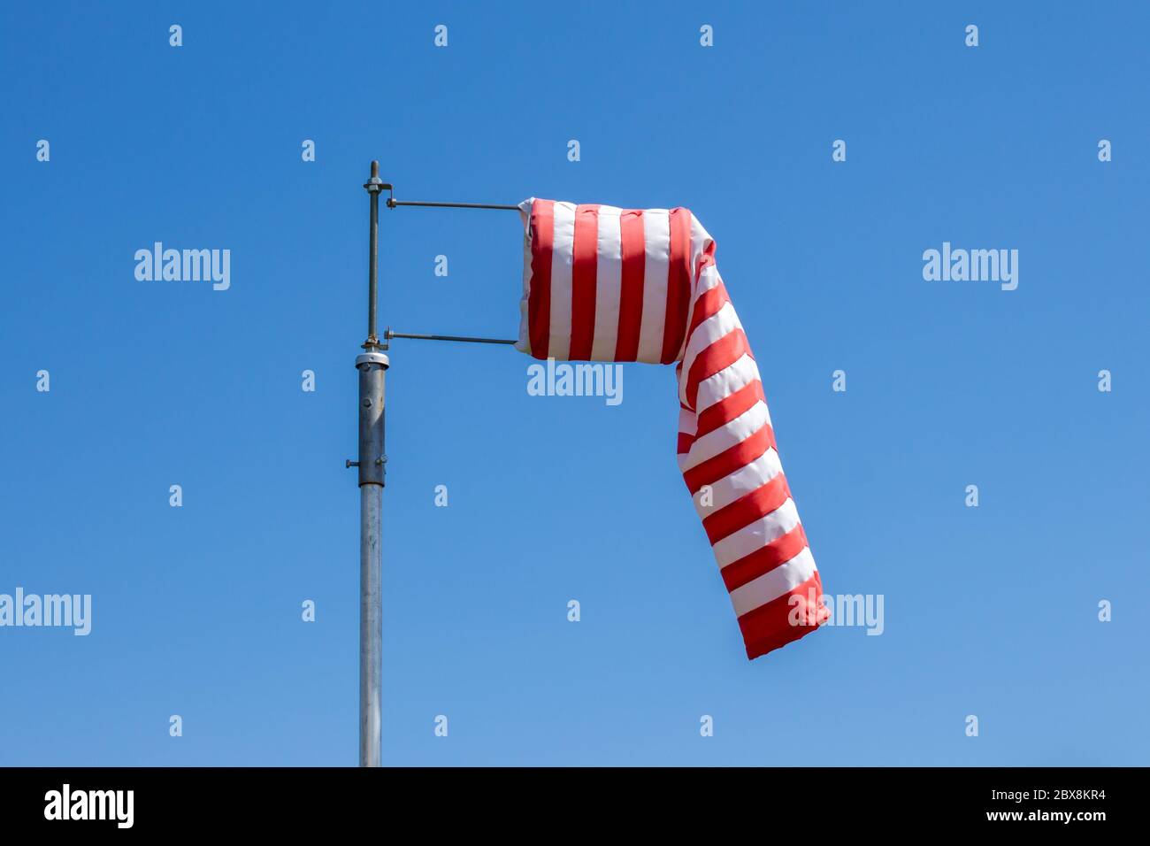 Drapeau de la protection contre le vent, sans vent, bandes rouges et blanches sur fond bleu Banque D'Images