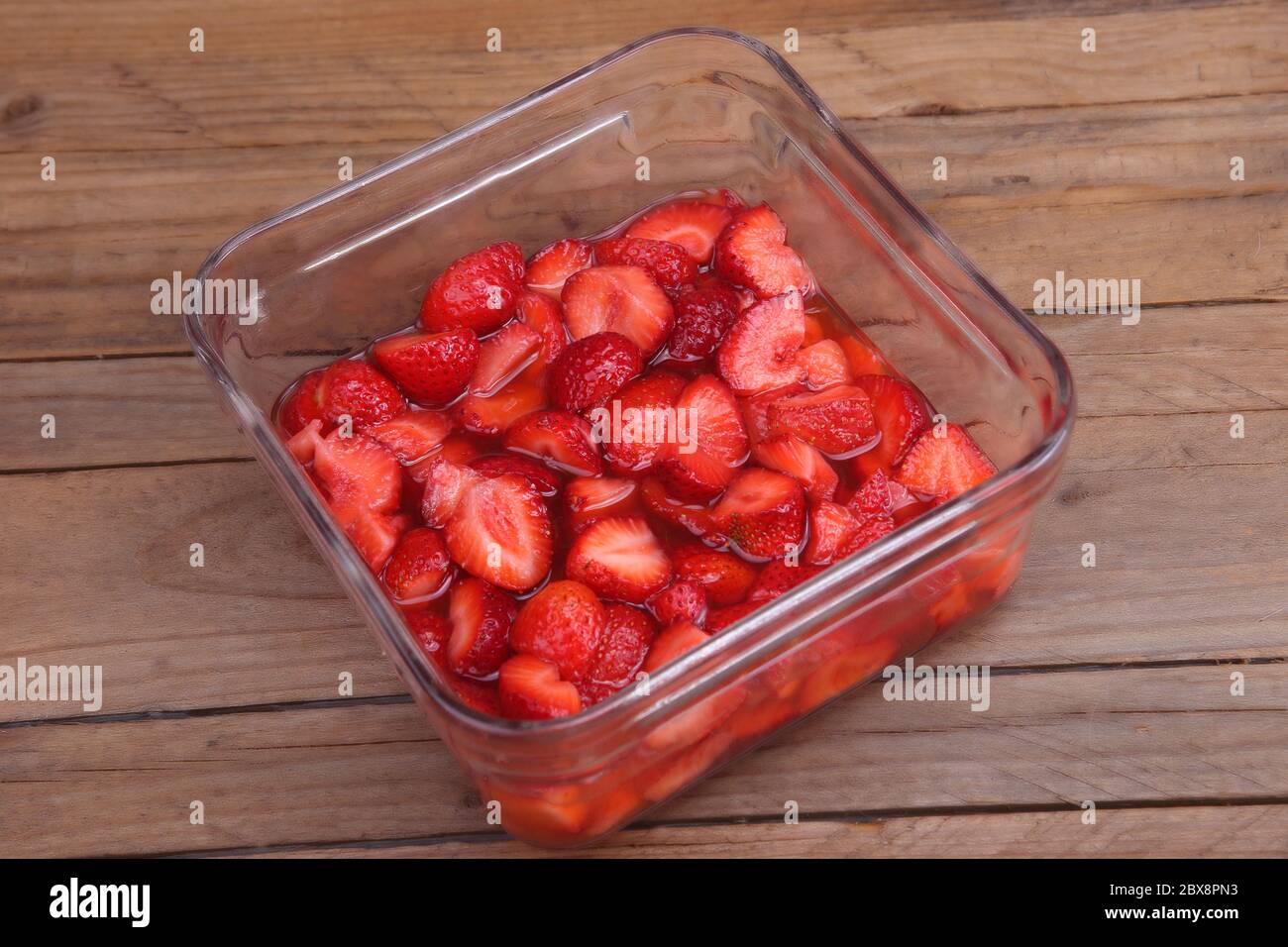 fraises dans un pot en verre sur une table en bois Banque D'Images